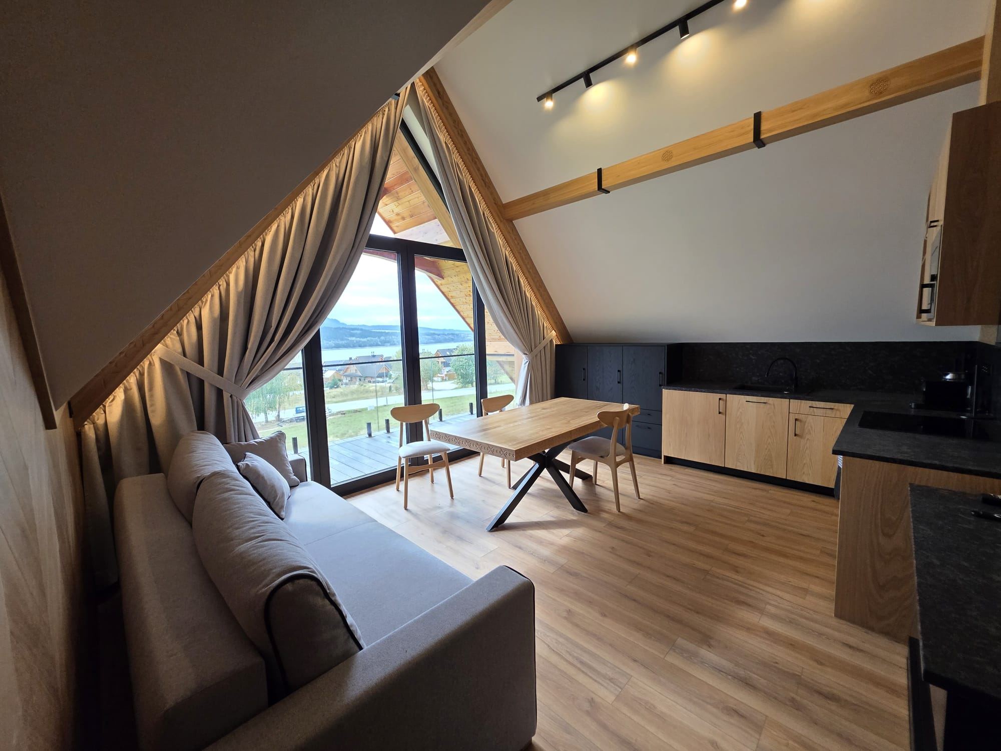 Salon apartamentu na poddaszu z widokiem na jezioro